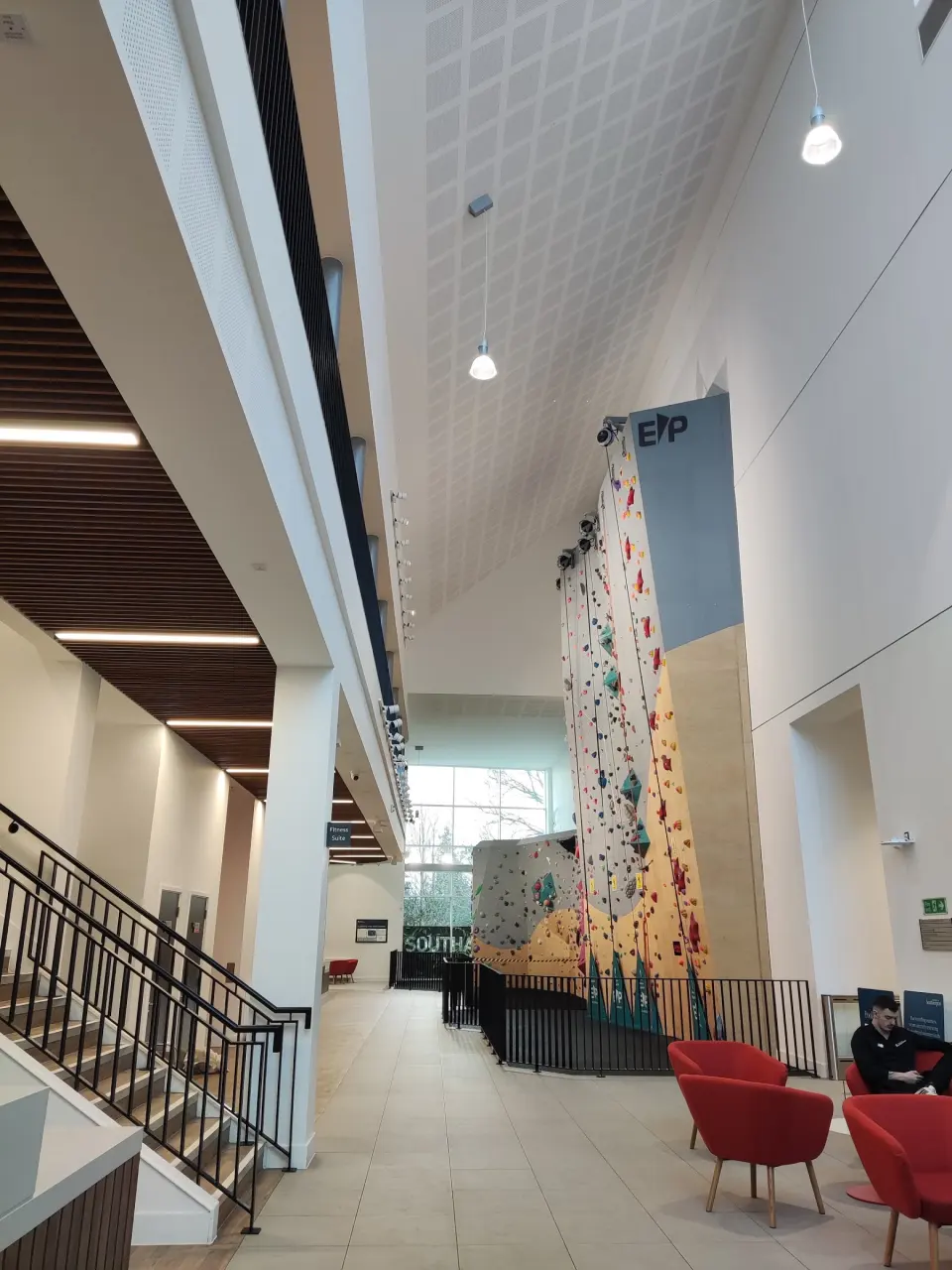 Tall auto-belay wall rising through the centre's atrium