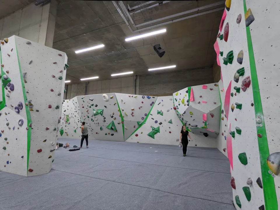 Bouldering hall with grey matting and tall white walls
