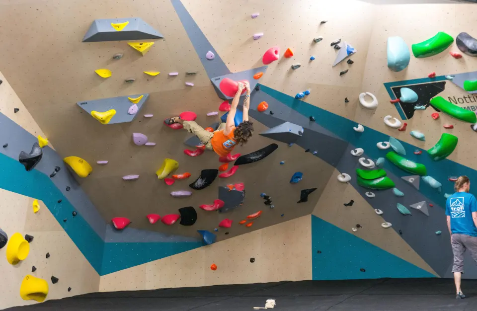 Climber on a steep wall of green and yellow holds