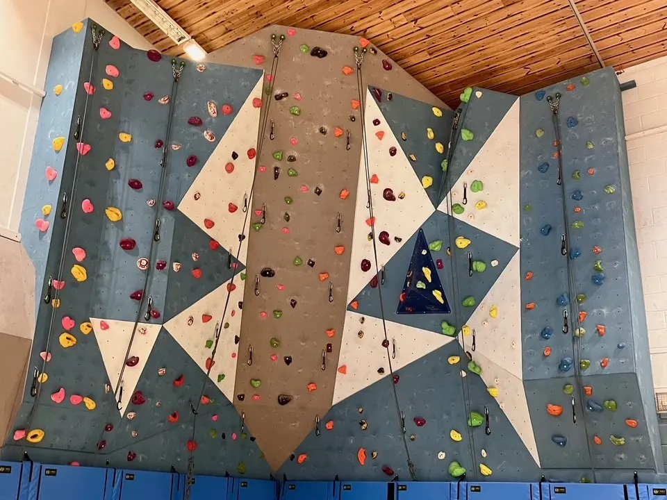 Panelled top-rope wall with blue matting in the sports hall