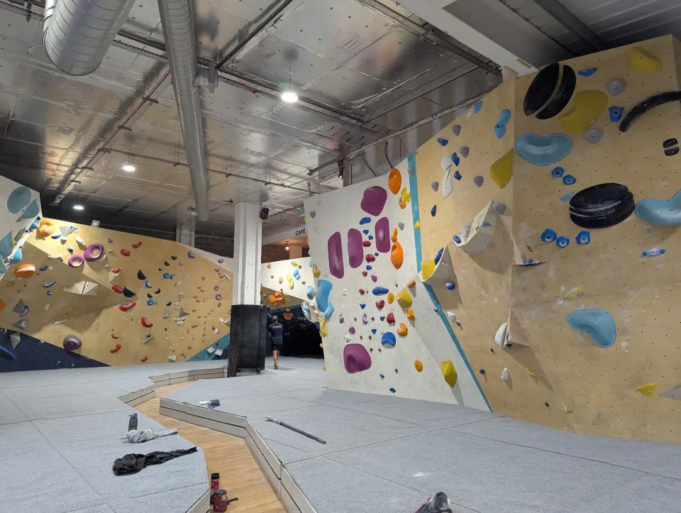Bouldering walls with grey matting and a central pillar