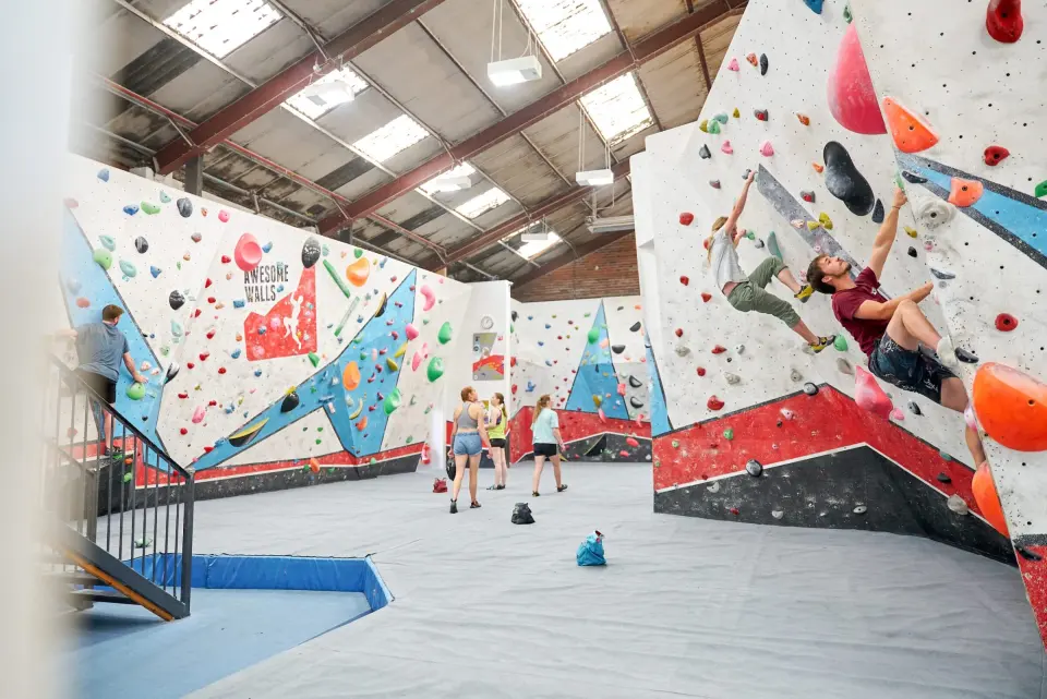Climbers on white and blue bouldering walls in the main hall at Awesome Walls Stoke