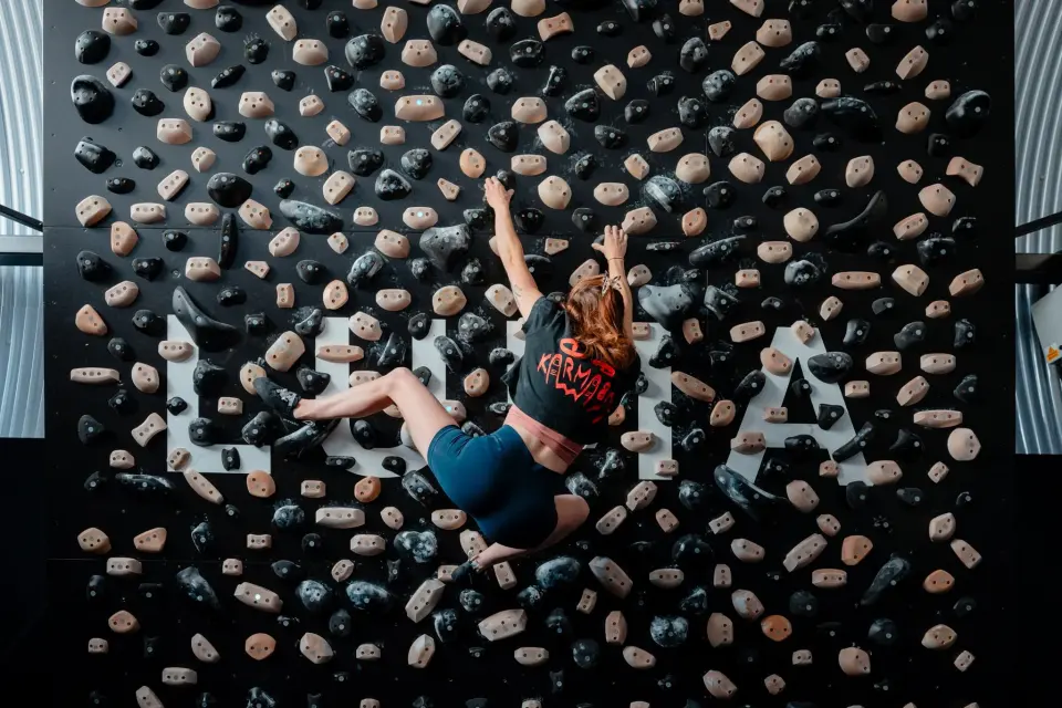 A climber on the LED-lit Tension Board in the railway-arch board gym at LUMA Climbing in Bath