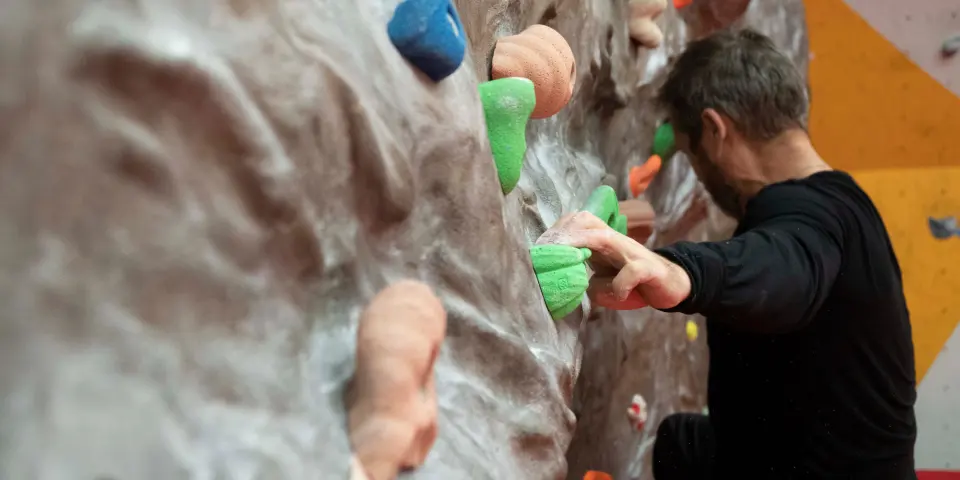 Climber reaching between holds on the bouldering wall