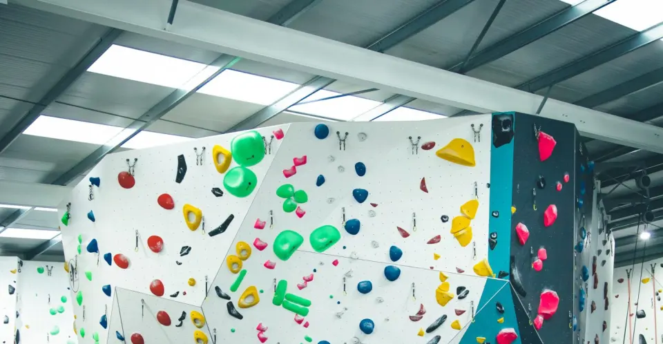 Bouldering walls with bright green and pink holds under the skylights at Parthian Climbing Southampton