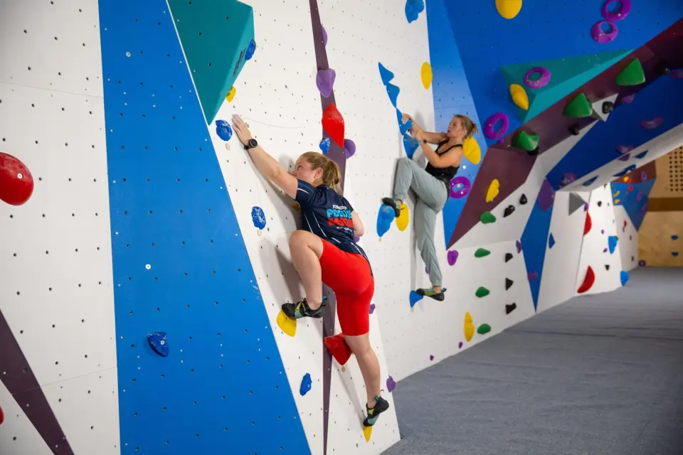 Two climbers on the blue and white bouldering wall at the University of Portsmouth's Ravelin Sports Centre
