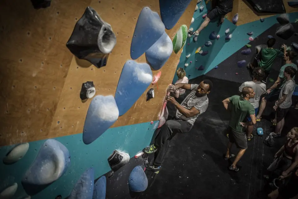 Climbers gathered under an overhanging bouldering wall with large volumes at Parthian Climbing Reading