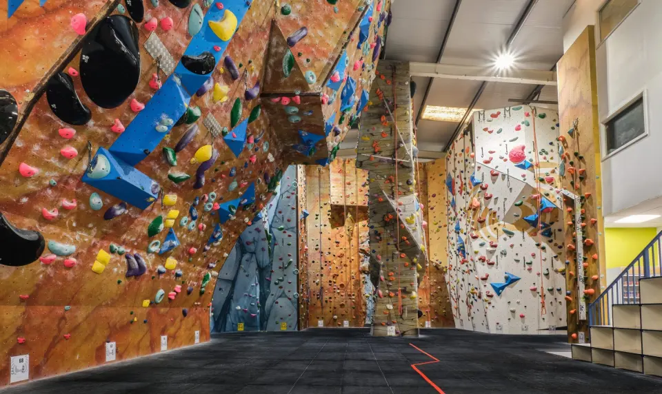 Tall orange and blue roped climbing walls with overhanging features at Blue Spider in Guildford