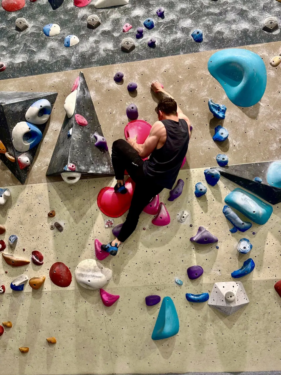 Climber on a steep wall dotted with large volumes