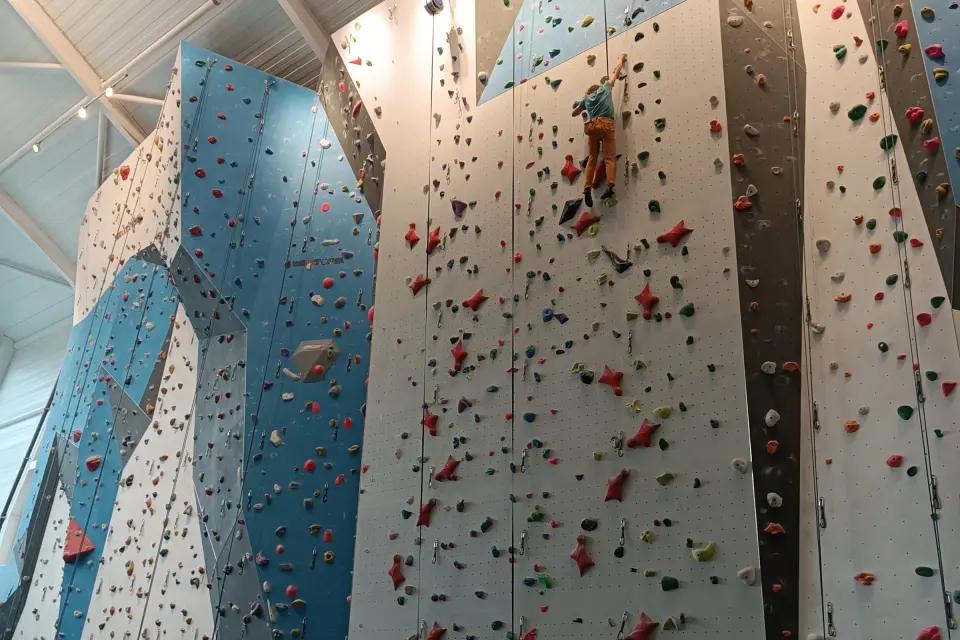 Climber on the tall lead and top-rope walls in the climbing hall