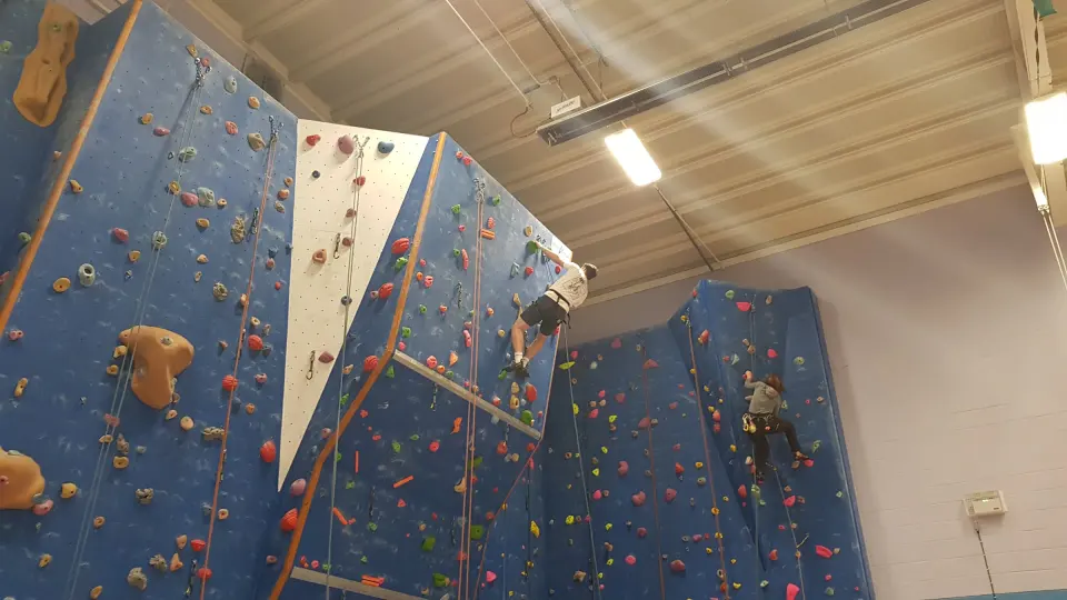 Two climbers on the blue roped walls