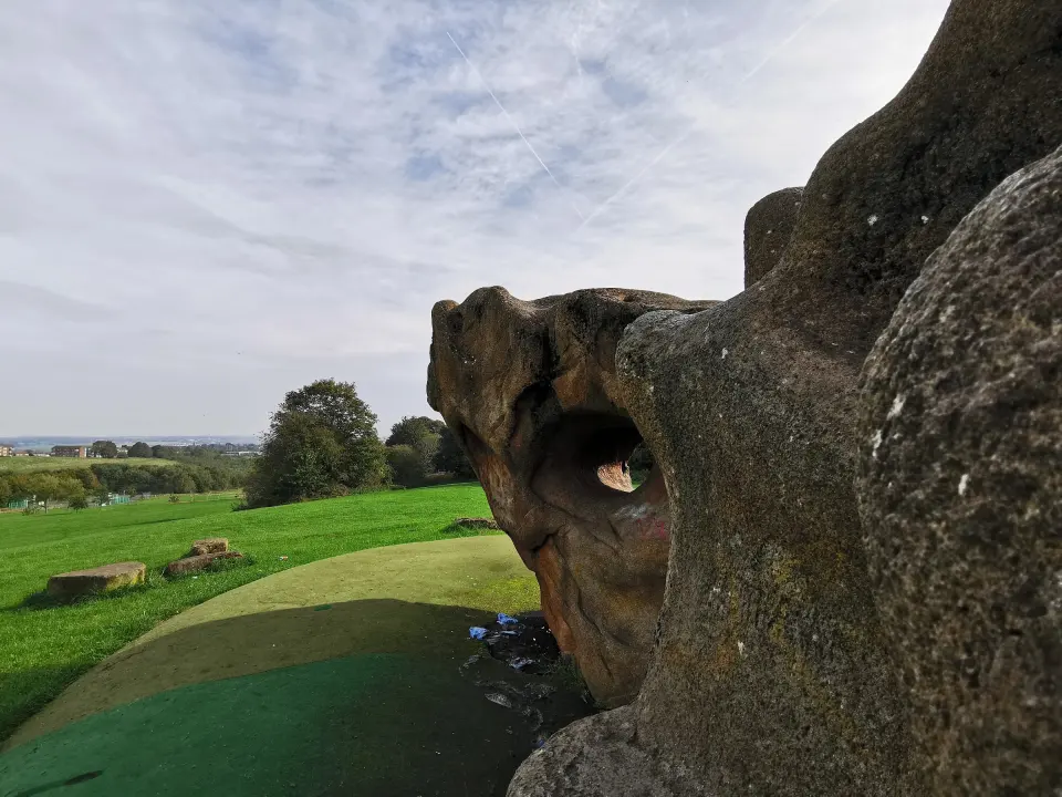Side of the boulder with a hole through it above the safety surface
