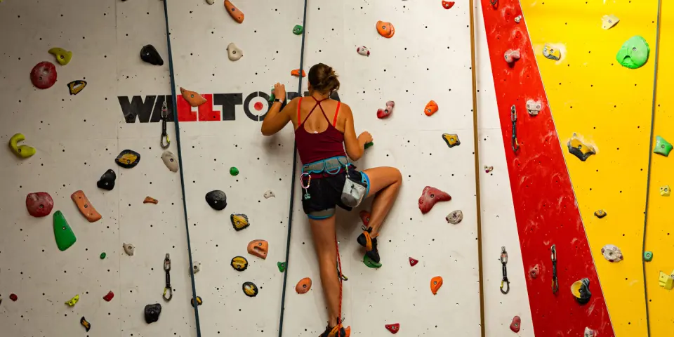 Climber on a white top-rope wall