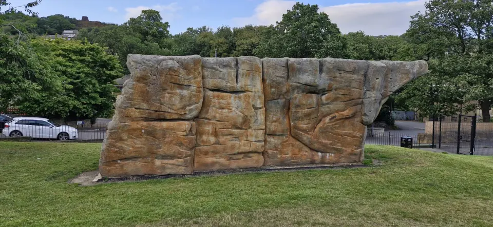 Cracks and carved features along the boulder's longest face