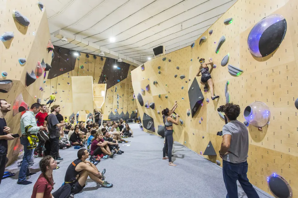 Climbers and spectators beside the wooden bouldering walls at Momentum Plovdiv