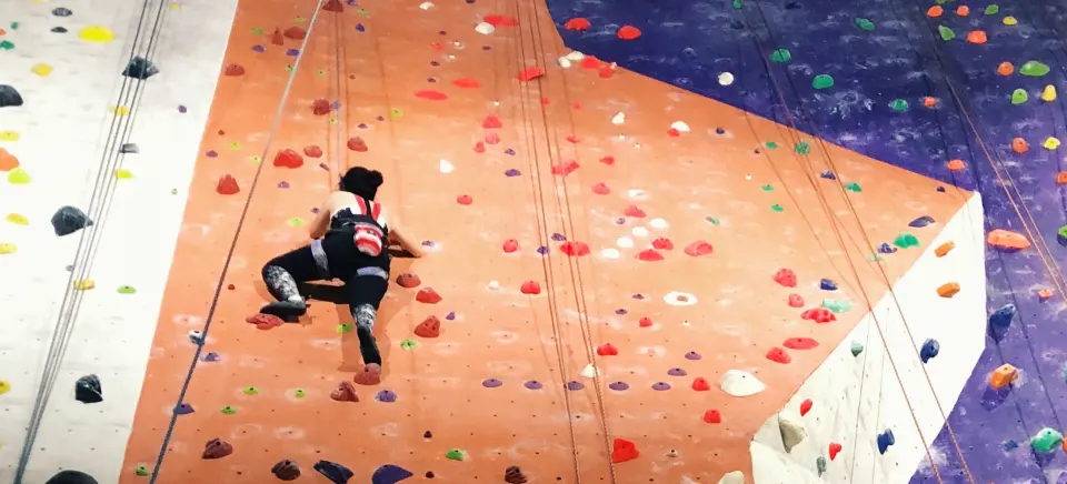 Climber on the orange roped wall shown by SPK Lapis