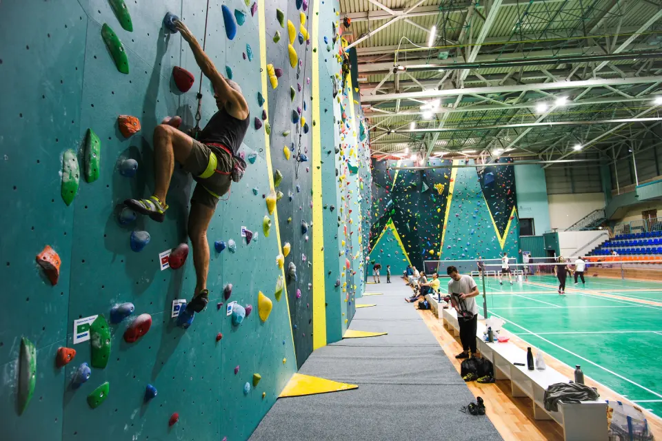 Climber and belayer on the blue and yellow walls at Europe Lyulin