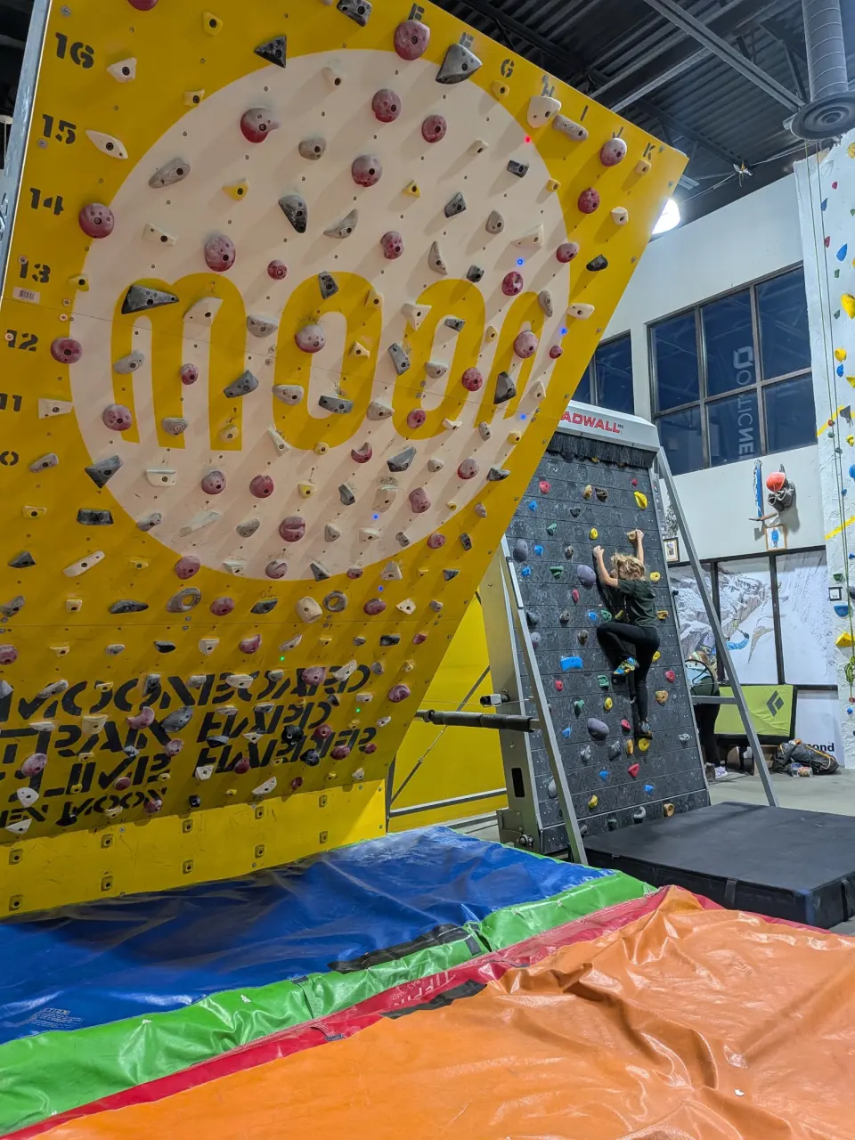 Climber on the Treadwall beside the yellow MoonBoard