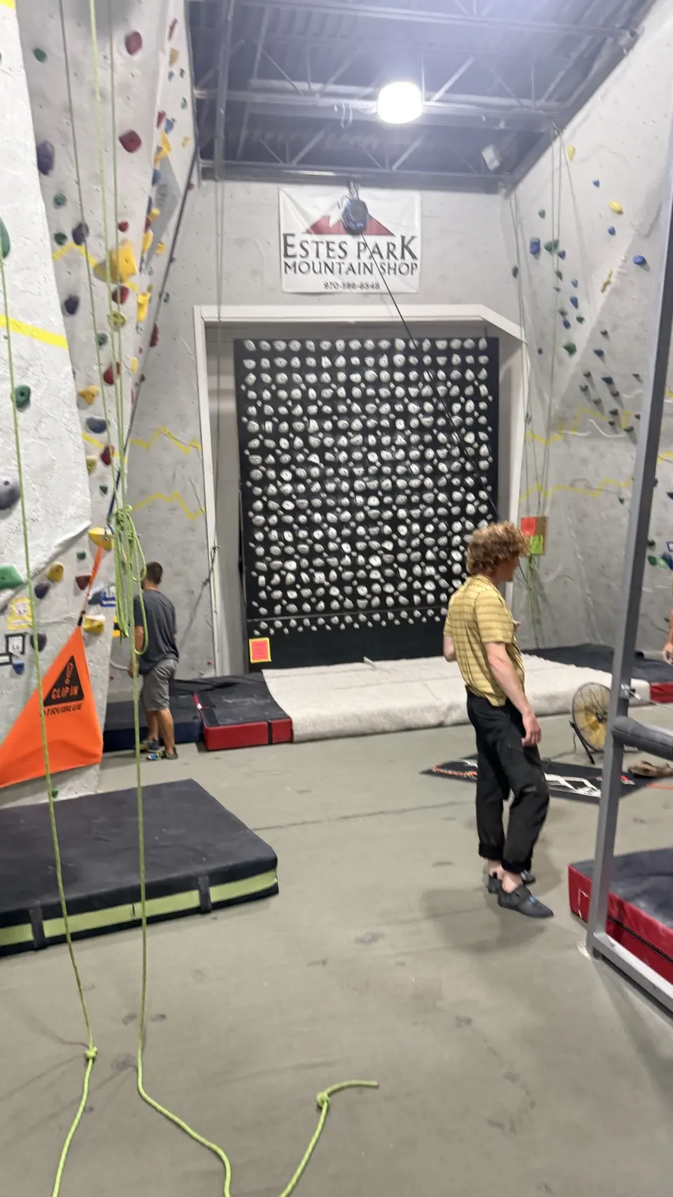 Hold-covered board between two roped walls, under the shop's banner