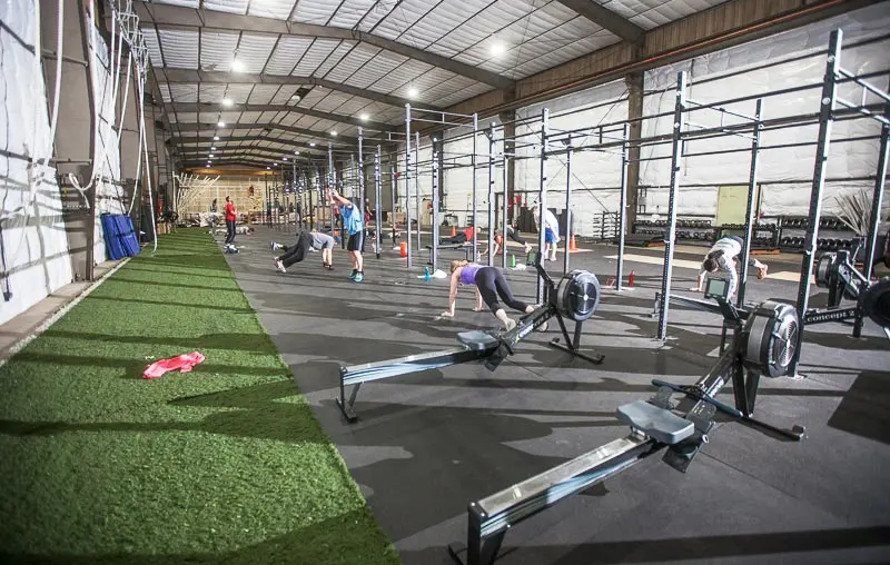 Strength and conditioning area with rowing machines, rigs and turf