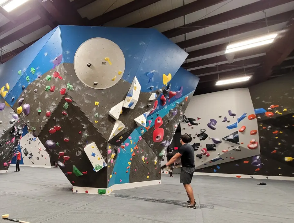 Freestanding boulder with blue and black faces in the main bouldering hall