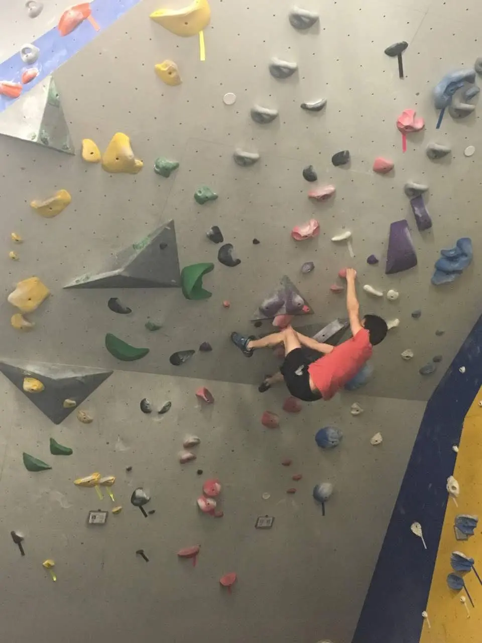 Climber working a problem on a grey wall
