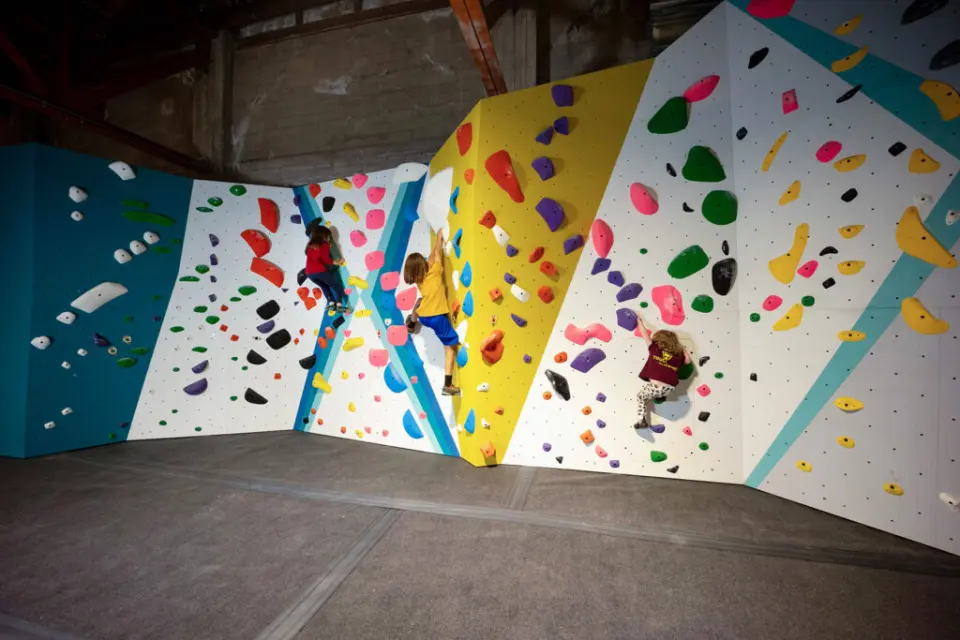 Climbers on colourful vertical bouldering walls