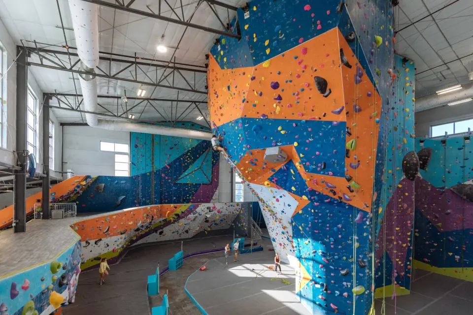 Orange and blue rope tower beside the long bouldering wall and ramp