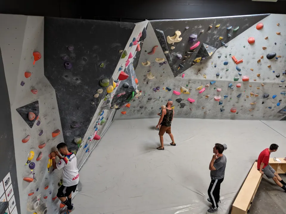 Climbers on the angled side wall above the matted floor