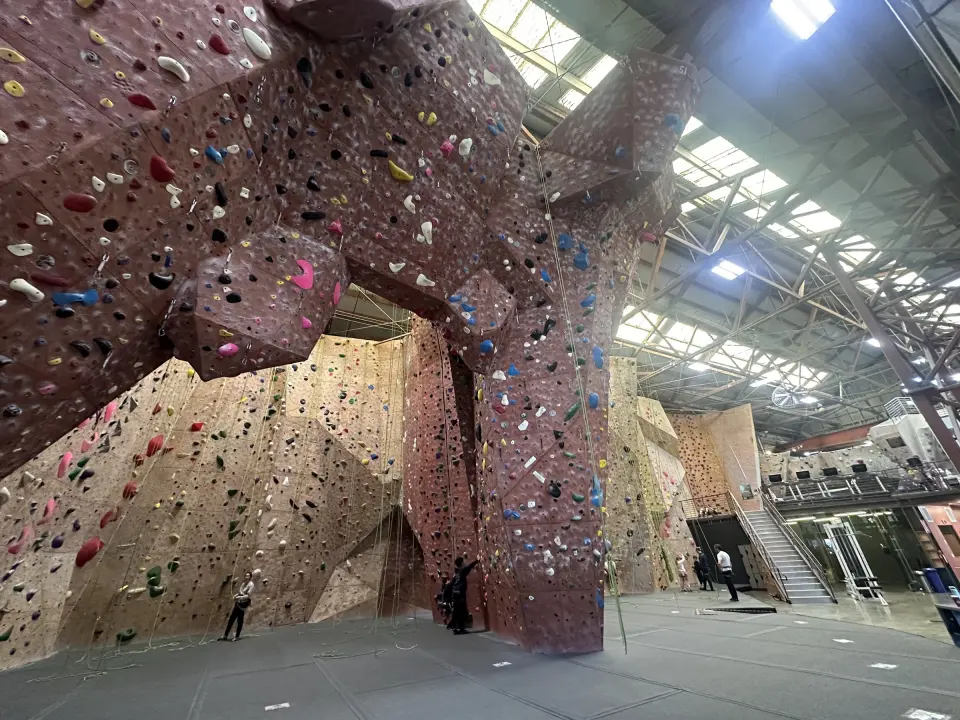 Tall roped walls arching under the skylit roof, with the mezzanine on the right