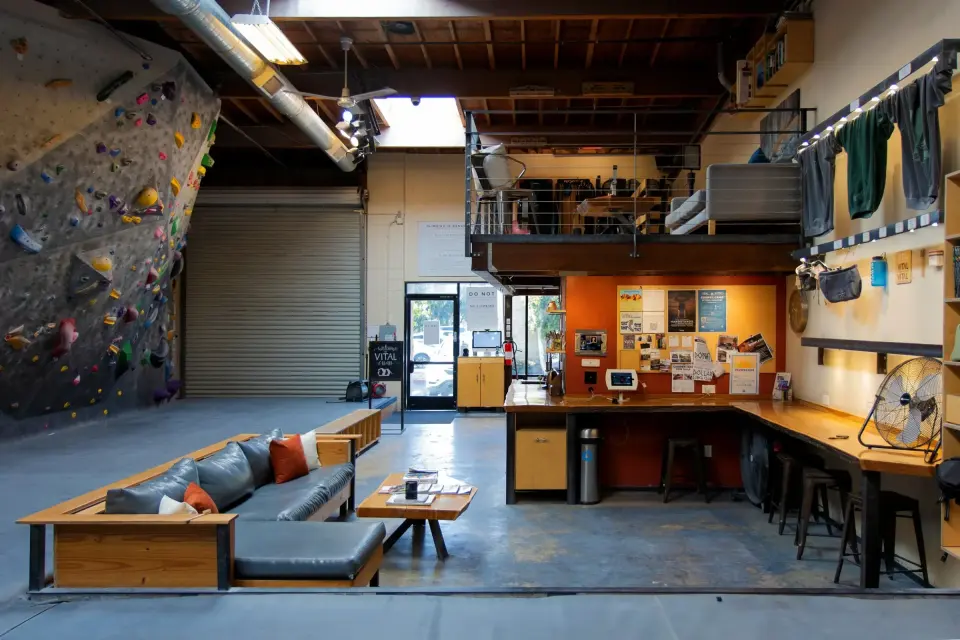 Bouldering wall beside the lounge sofa, front desk and mezzanine
