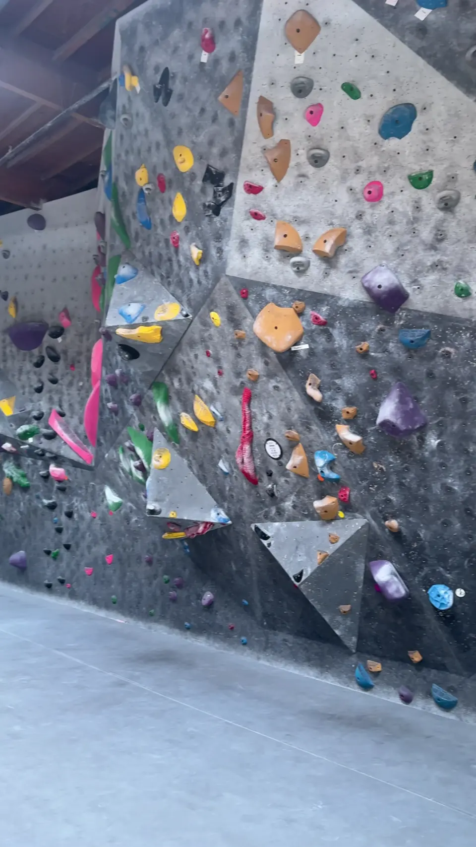 Tall bouldering wall with volumes and colourful holds