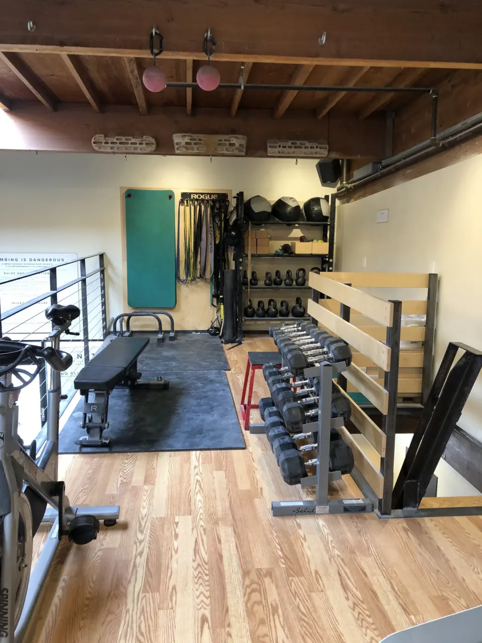 Fitness room with dumbbells, bench, kettlebells and an exercise bike