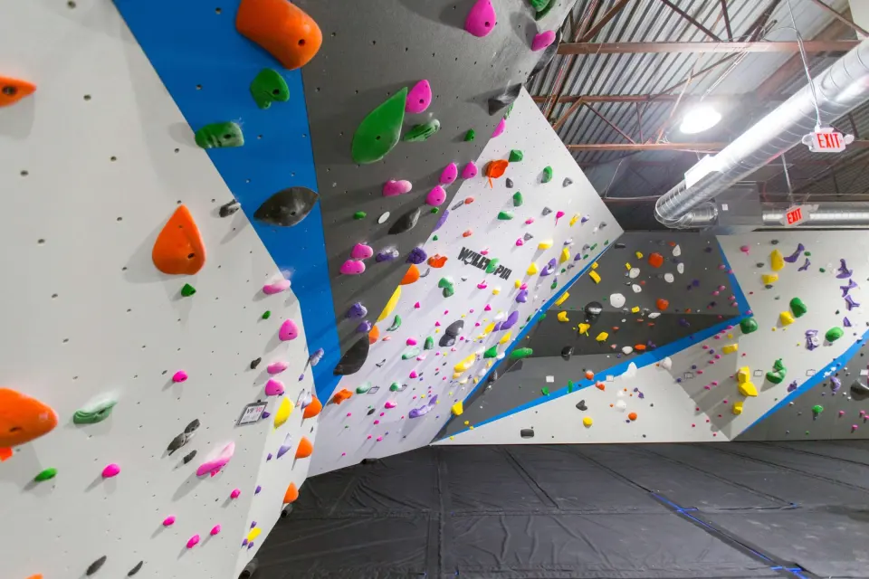 Bouldering walls with blue-edged panels and coloured holds