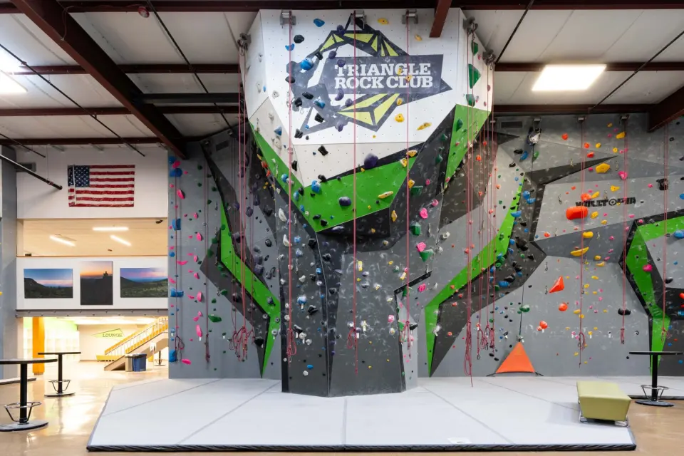 Roped climbing tower topped with the Triangle Rock Club logo