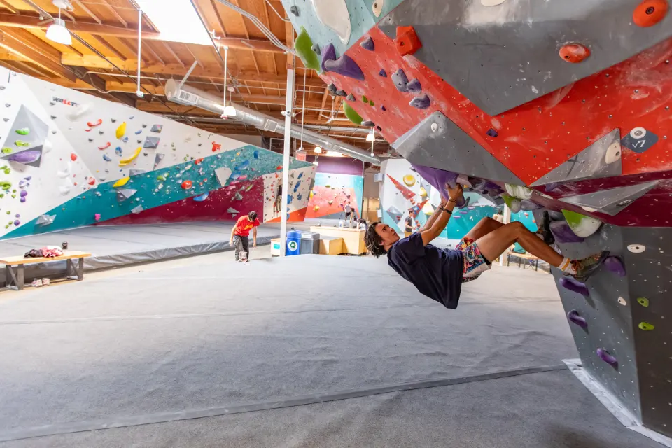 Climber on an overhang in the wide bouldering hall