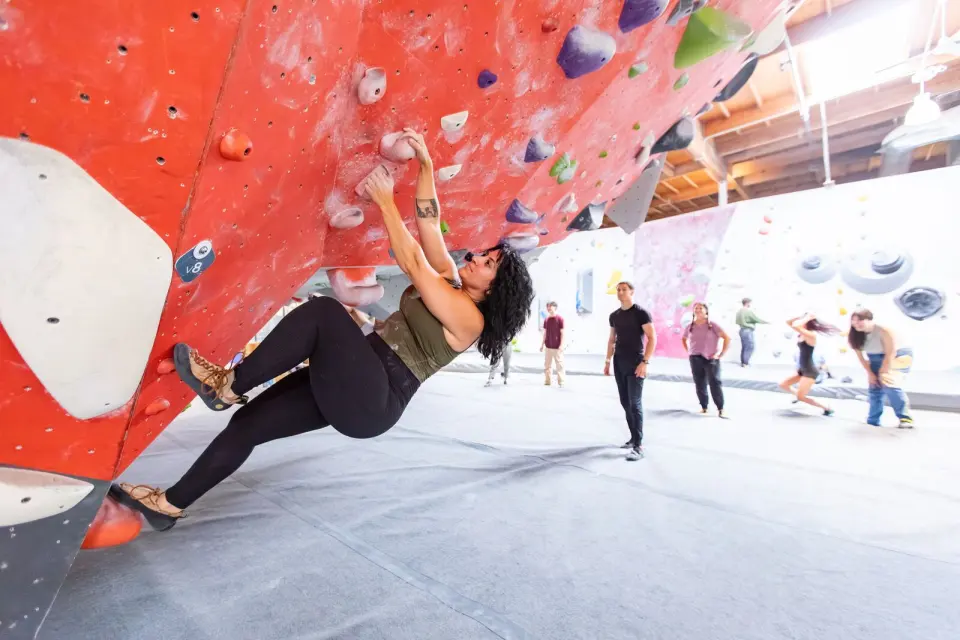 Climber under a red overhang in the bouldering area