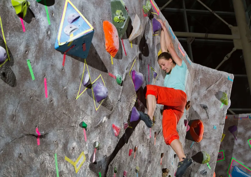 Climber on the textured grey bouldering wall