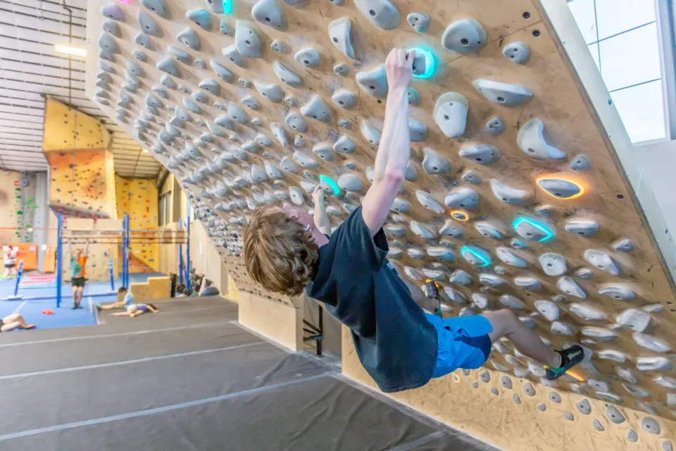 Climber on the lit Kilter Board
