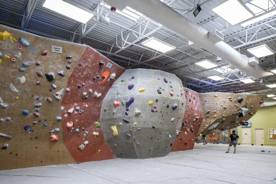 Bouldering area with a large grey sphere feature and red and grey walls