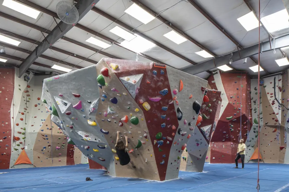 Freestanding top-out boulder in front of the roped walls