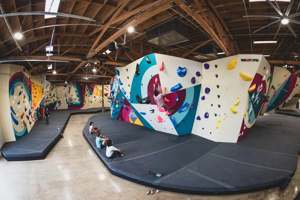 Colourful freestanding boulder on the matted floor under the wooden roof trusses
