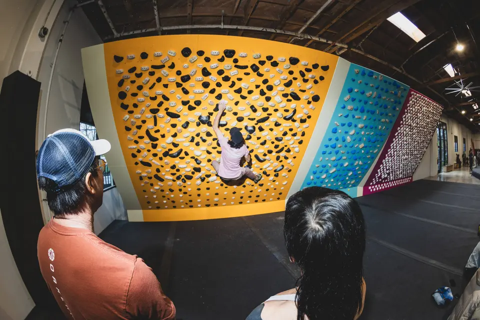 Climber on the yellow training board beside the other boards