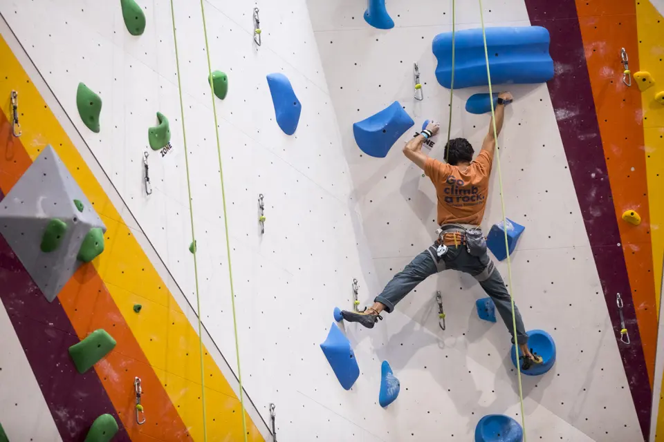 Climber on a route over yellow and orange stripes