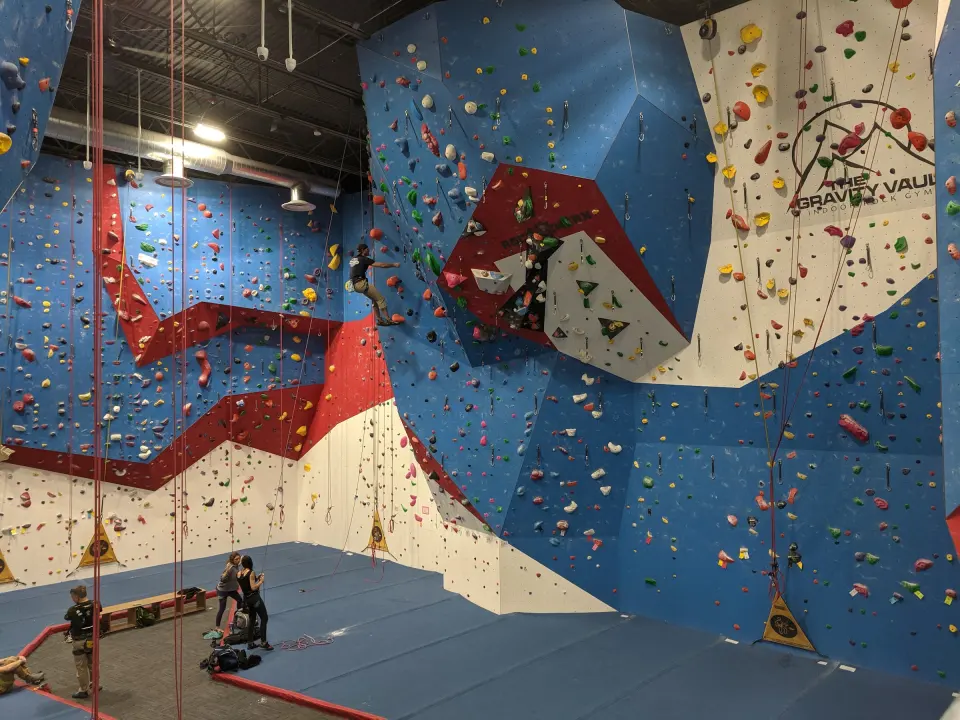 Blue, red and white top-rope walls with The Gravity Vault logo above the matting