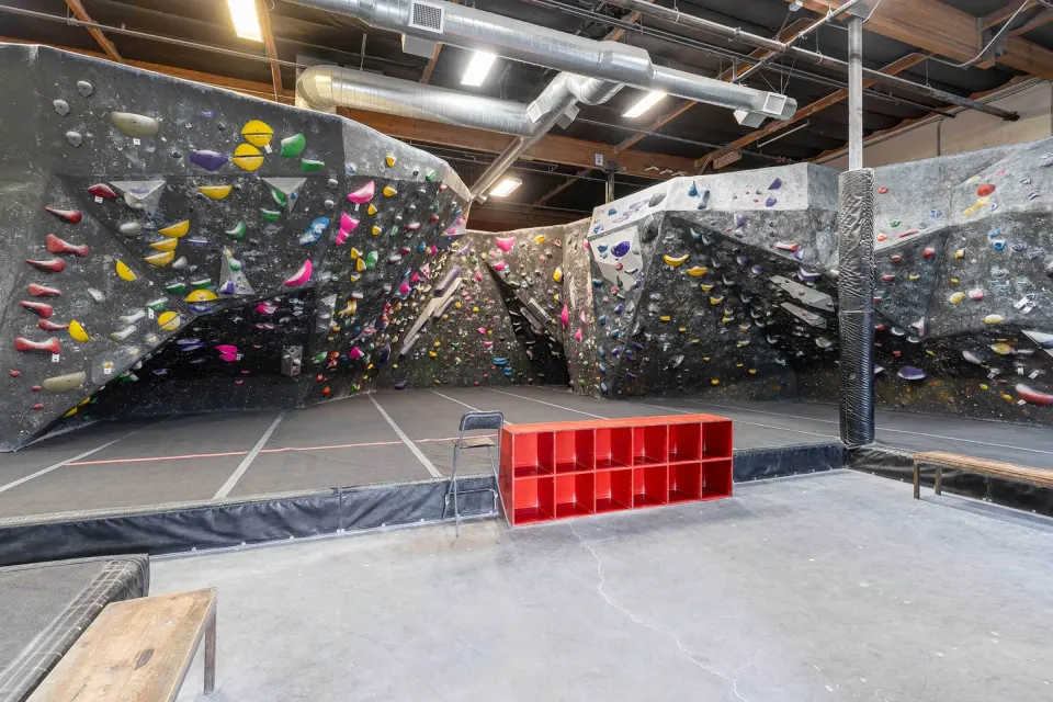 Main bouldering area with overhanging grey walls and colourful holds