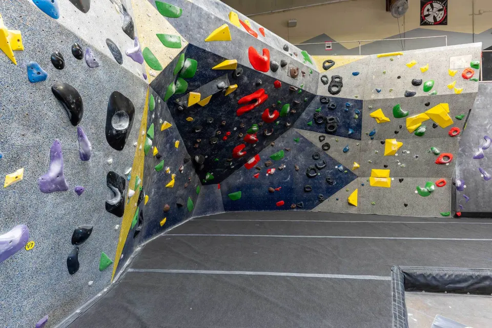 Steep bouldering wall with black and yellow volumes