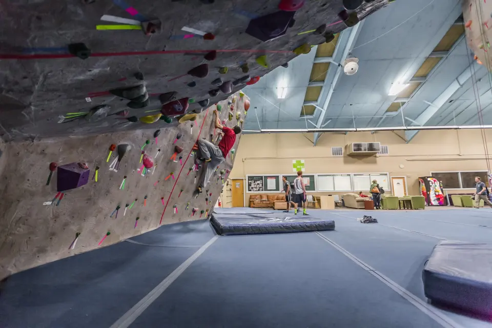 Overhanging wall above matting, with the lounge behind