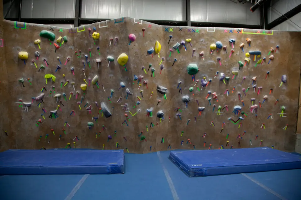 Long bouldering wall above blue crash mats