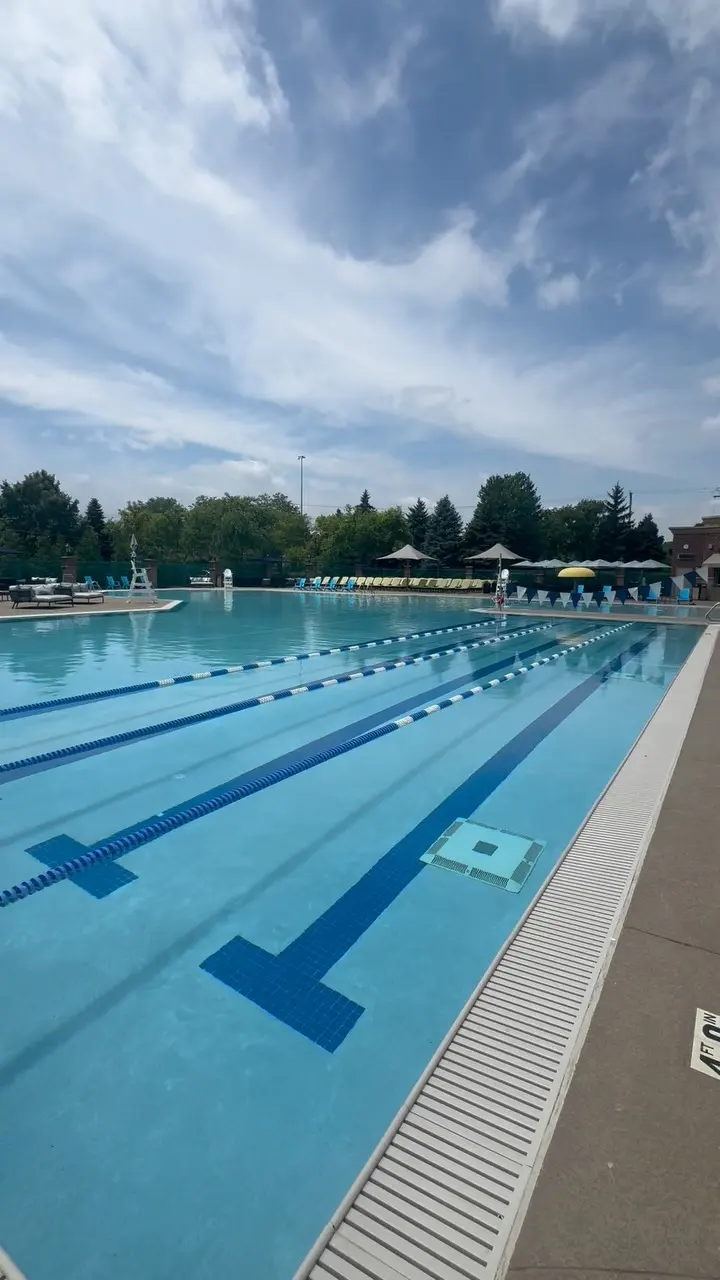 Outdoor lap pool with lane lines and poolside umbrellas